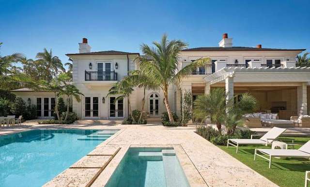 The rear garden of a Phipps Estates residence in Palm Beach, with a coquina-edged pool and spa, palms, and a loggia behi – AGTLAND Landscape Architecture