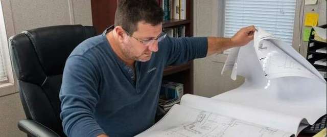 Owner of the company looking at blueprints in West Palm Beach, FL. – Evergreen Sprinkler & Landscaping