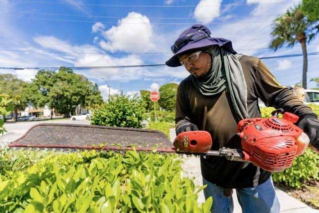 Green Image crew member trimming a hedge on an HOA property – Green Image